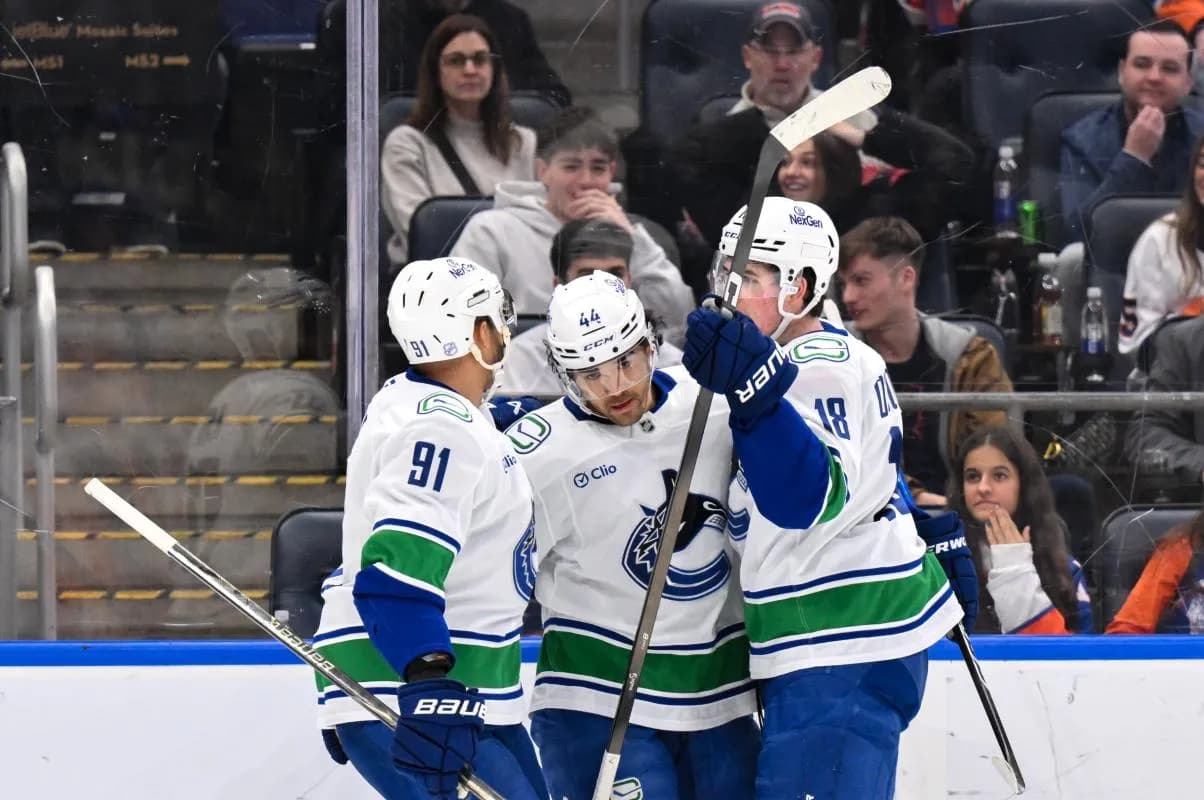 Vancouver Canucks left wing Kiefer Sherwood (44) celebrates with teammates after scoring a goal against the New York Islanders during the first period at UBS Arena.