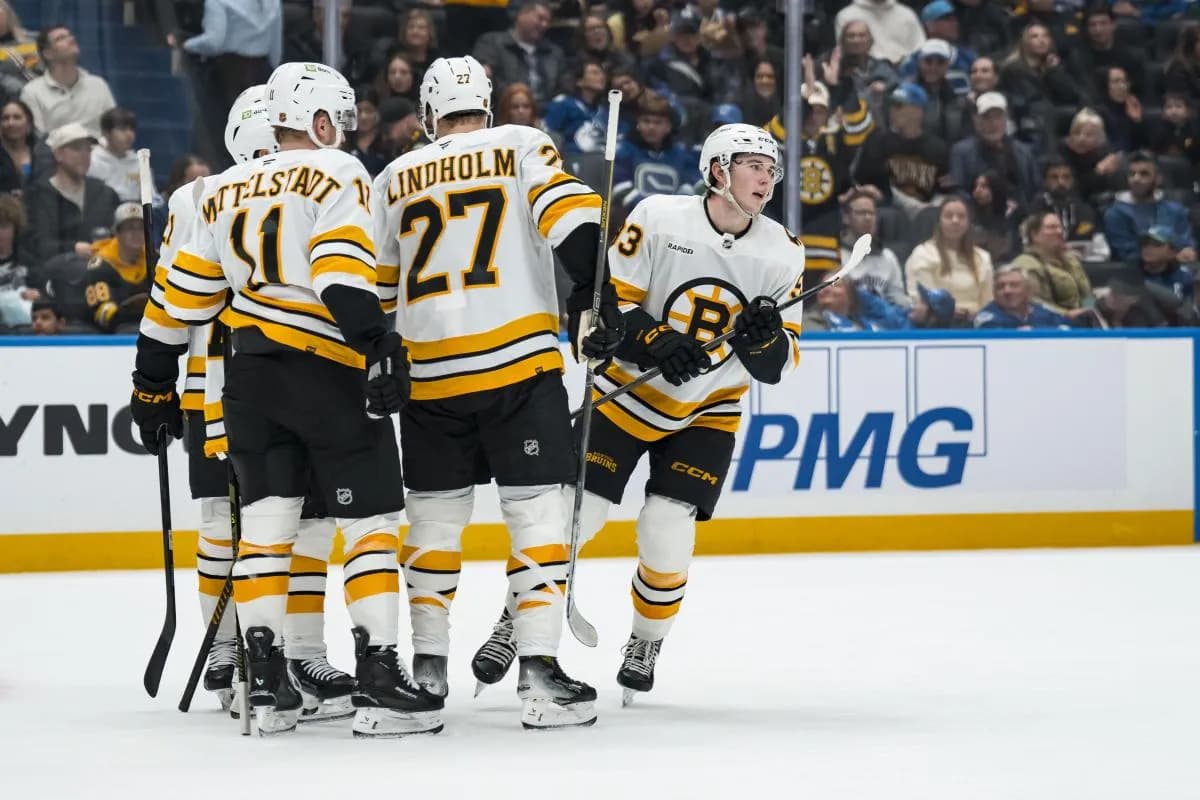 Boston Bruins forward Fraser Minten (93) celebrates with forward Casey Mittelstadt (11) and defenseman Hampus Lindholm (27) after scoring a goal against the Vancouver Canucks in the first period at Rogers Arena.