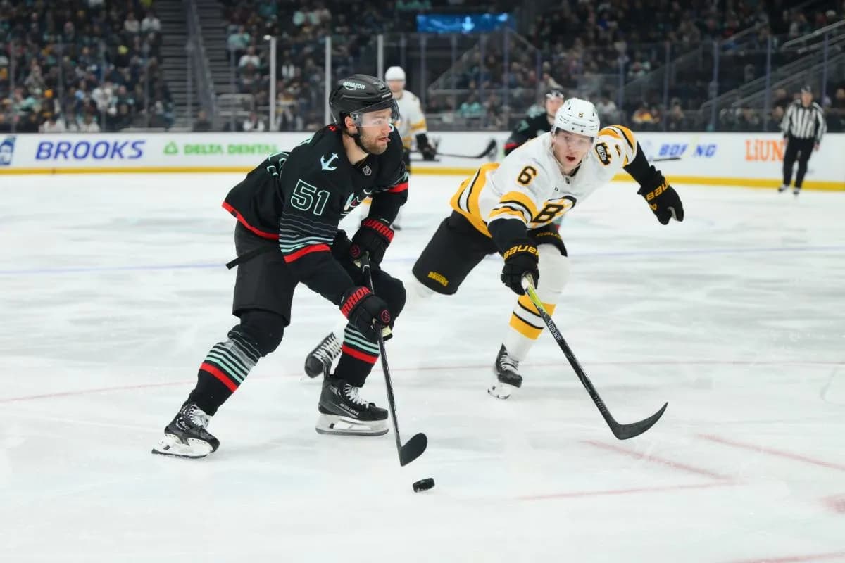 Seattle Kraken center Shane Wright (51) advances the puck while defended by Boston Bruins defenseman Mason Lohrei (6) during the second period at Climate Pledge Arena.