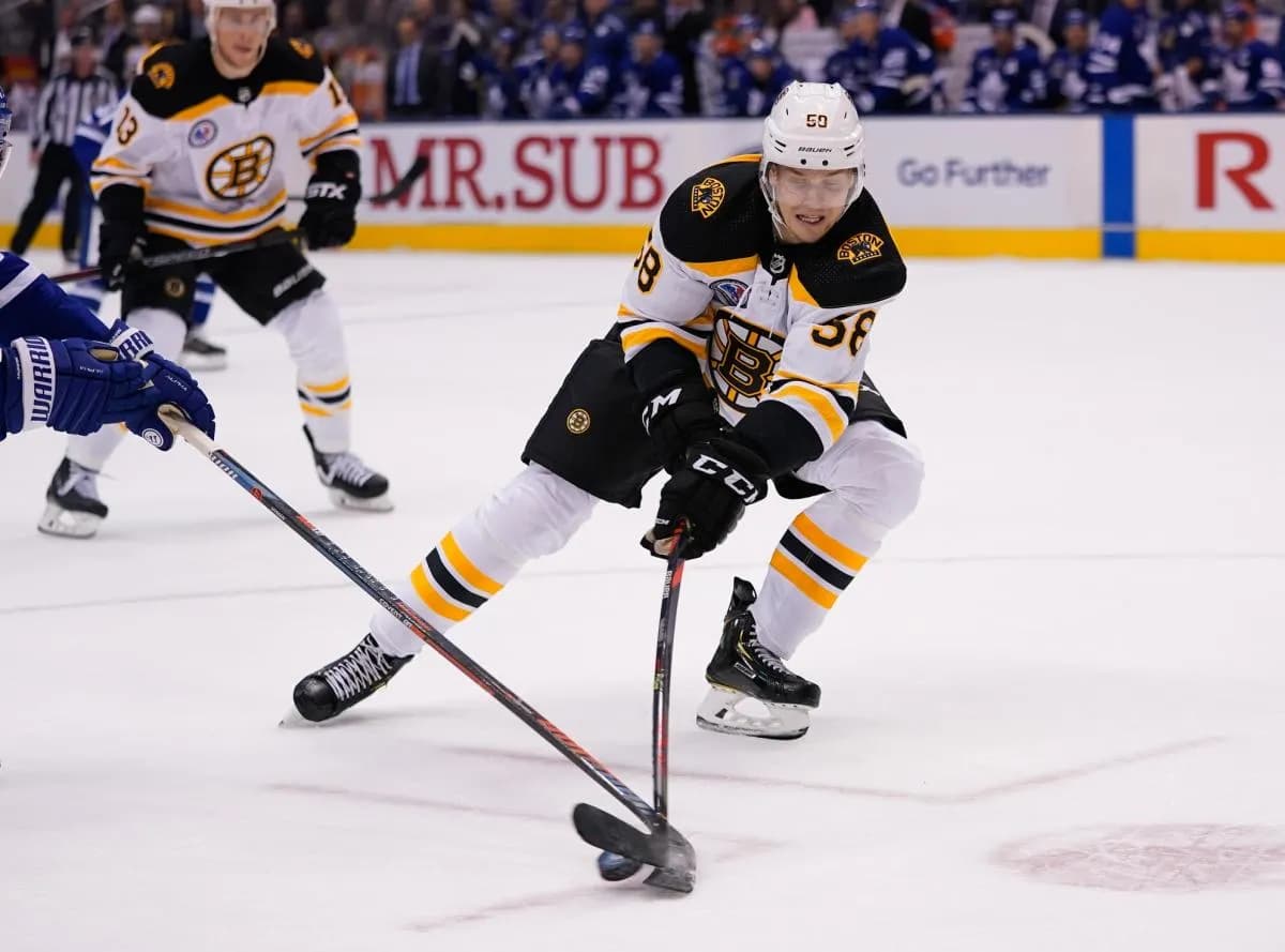 Boston Bruins defenseman Urho Vaakanainen (58) tries to control the puck against the Toronto Maple Leafs at Scotiabank Arena. Boston defeated Toronto.