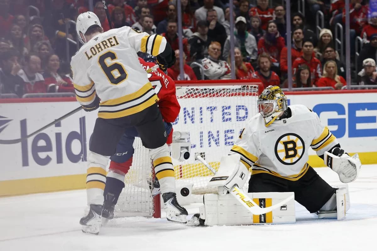 Washington Capitals left wing Connor McMichael (24) deflects the puck on Boston Bruins goaltender Jeremy Swayman (1) as Bruins defenseman Mason Lohrei (6) defends during the first period at Capital One Arena.