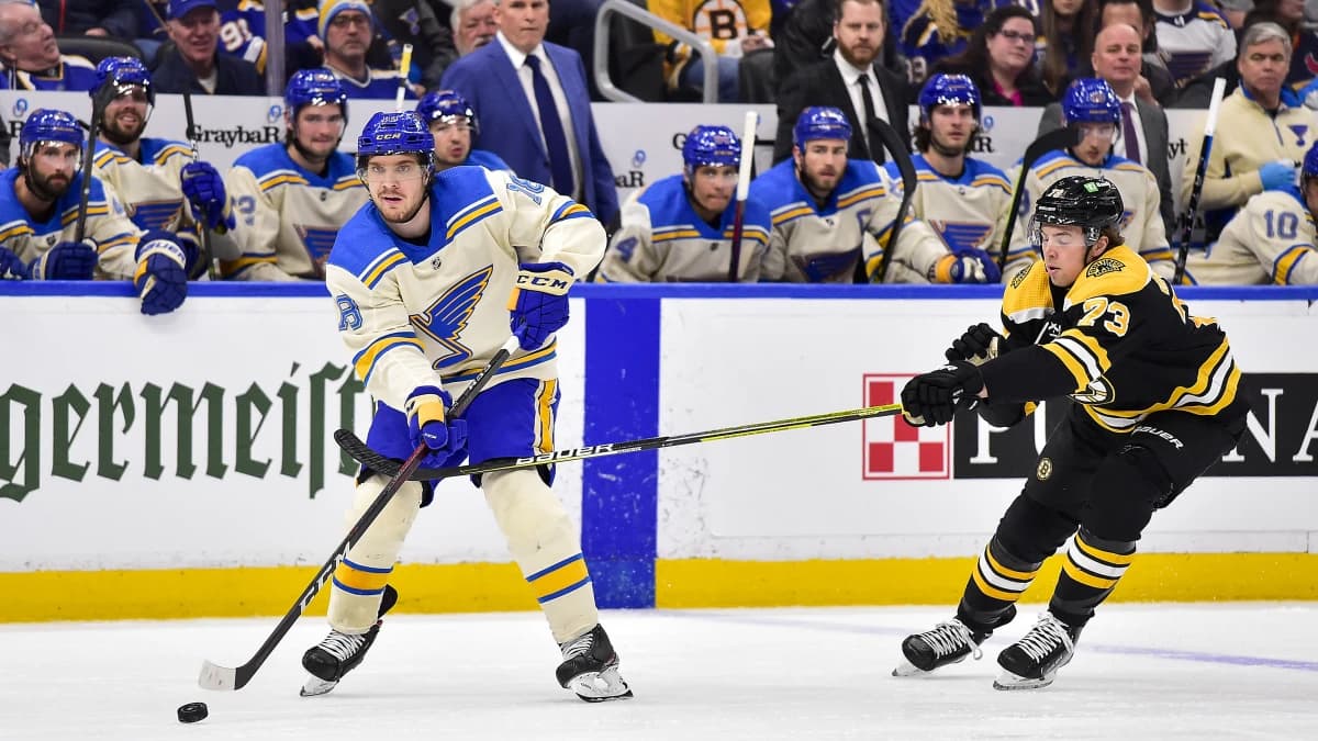 St. Louis Blues center Robert Thomas (18) passes the puck as Boston Bruins defenseman Charlie McAvoy (73) defends during the first period at Enterprise Center