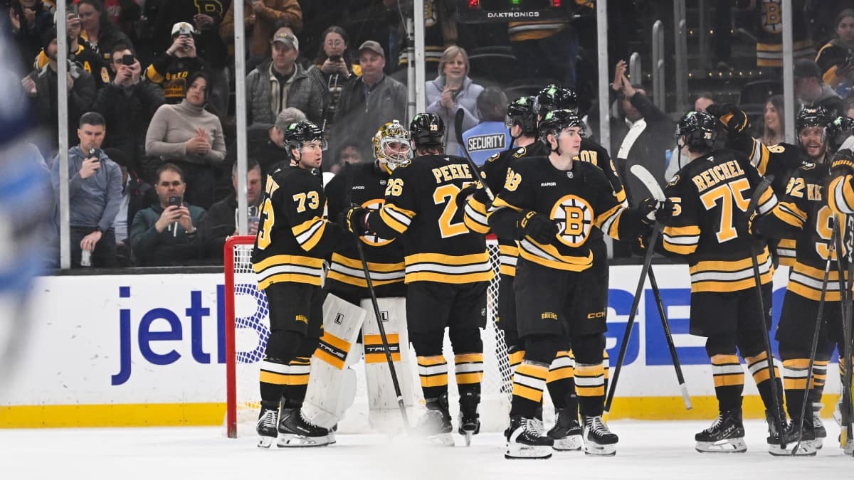 Boston Bruins goaltender Jeremy Swayman (1) celebrates defeating the Winnipeg Jets with defenseman Andrew Peeke (26) and defenseman Charlie McAvoy (73) at TD Garden.