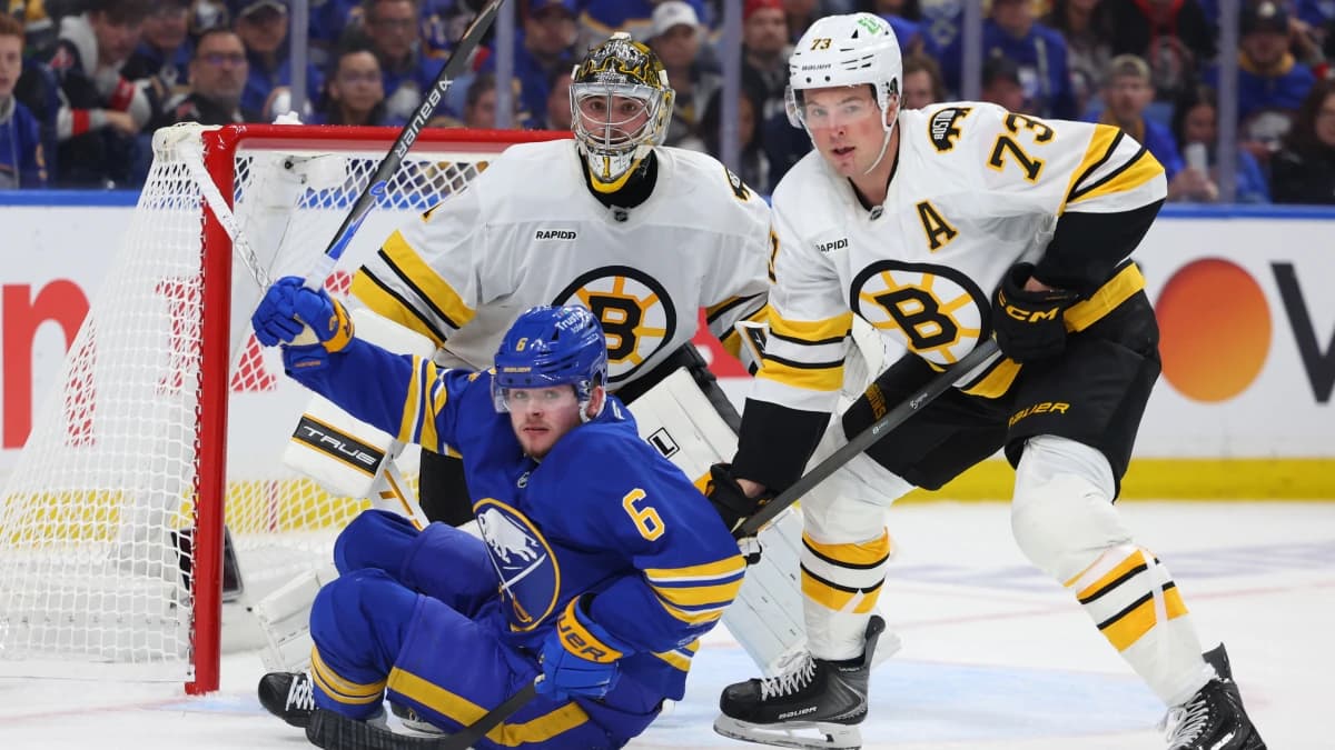 Boston Bruins defenseman Charlie McAvoy (73) knocks down Buffalo Sabres left wing Zach Benson (6) in front of the net as Boston Bruins goaltender Jeremy Swayman (1) watches the puck during the second period in game one of the first round of the 2026 Stanley Cup Playoffs at KeyBank Center.