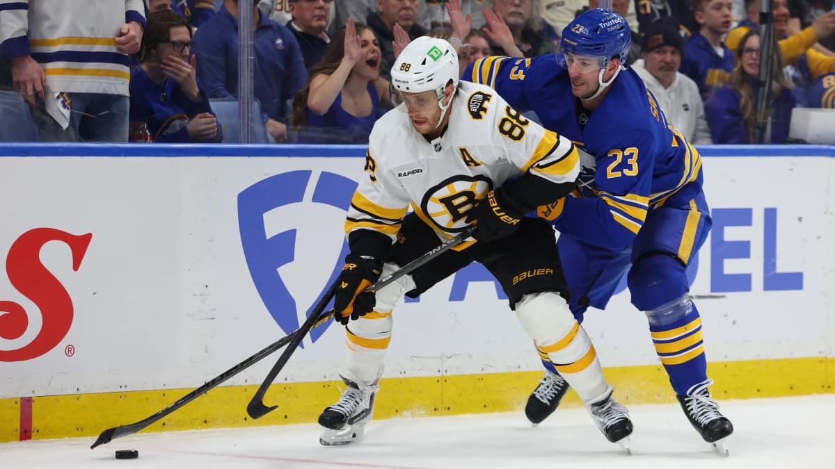 Boston Bruins right wing David Pastrnak (88) skates with the puck as Buffalo Sabres defenseman Mattias Samuelsson (23) defends during the third period in game one of the first round of the 2026 Stanley Cup Playoffs at KeyBank Center.