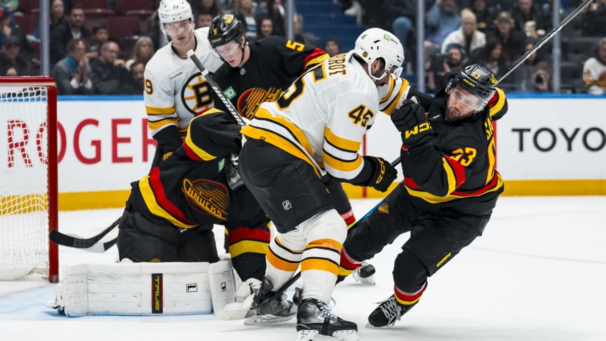 Boston Bruins defenseman Jonathan Aspirot (45) checks Vancouver Canucks forward Max Sasson (63) in the third period at Rogers Arena.