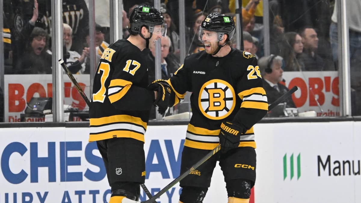 Boston Bruins defenseman Will Borgen (17) celebrates an empty net goal against the San Jose Sharks with center Elias Lindholm (28) during the third period at TD Garden