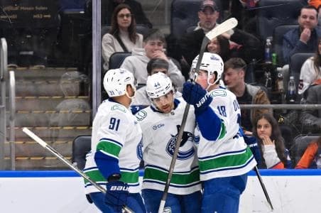 Vancouver Canucks left wing Kiefer Sherwood (44) celebrates with teammates after scoring a goal against the New York Islanders during the first period at UBS Arena.