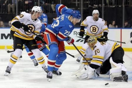 Boston Bruins goaltender Joonas Korpisalo (70) makes a save against New York Rangers center Matt Rempe (73) in front of Bruins center Fraser Minten (93) during the second period at Madison Square Garden.