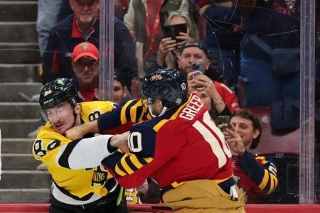 Boston Bruins left wing Tanner Jeannot (84) and Florida Panthers left wing A.J. Greer (10) fight during the first period at Amerant Bank Arena.
