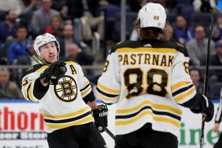 Boston Bruins left wing Brad Marchand (63) celebrates his goal against the New York Islanders with right wing David Pastrnak (88) during the third period at UBS Arena.