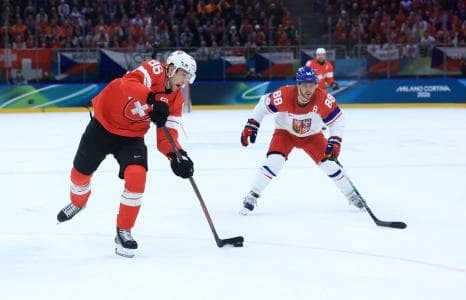 Janis Moser of Switzerland in action with David Pastrnak of Czech Republic in men's ice hockey group A play during the Milano Cortina 2026 Olympic Winter Games at Milano Santagiulia Ice Hockey Arena.