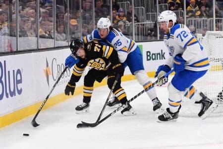 Boston Bruins left wing Viktor Arvidsson (71) battles for the puck with St. Louis Blues defenseman Tyler Tucker (75) and defenseman Justin Faulk (72) during the first period at TD Garden.