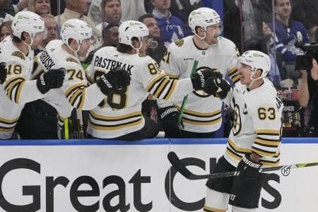 Boston Bruins forward Jake DeBrusk (74) and forward David Pastrnak (88) congratulate forward Brad Marchand (63) on his first goal of the game against the Toronto Maple Leafs during the third period of game three of the first round of the 2024 Stanley Cup Playoffs at Scotiabank Arena