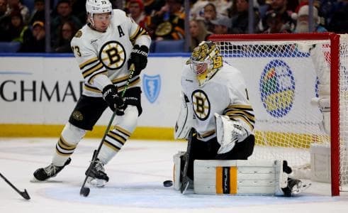 Boston Bruins defenseman Charlie McAvoy (73) watches as goaltender Jeremy Swayman (1) makes a save during the second period against the Buffalo Sabres at KeyBank Center.