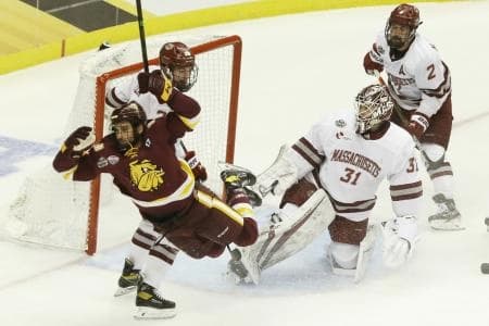 Minnesota Duluth Bulldogs forward Koby Bender (11) falls to the ice while playing the puck against UMass Minutemen goalie Matt Murray (31) during the second period in the semifinals of the 2021 Frozen Four NCAA hockey tournament at PPG Paints Arena.