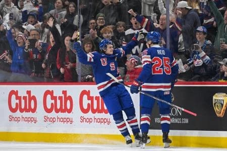 USA defensemen Chase Reid (25) celebrates his power play goal against Sweden with forward James Hagens (10) during the second period in group play during the 2026 IIHF World Junior Championship at Grand Casino Arena.