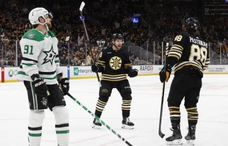 As Dallas Stars center Tyler Seguin (91) skates by, Boston Bruins defenseman Matt Grzelcyk (48) celebrates a goal by left wing David Pastrnak (88) to tie the game late in the third period at TD Garden