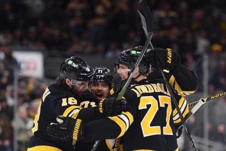 Boston Bruins center Pavel Zacha (18) left wing Viktor Arvidsson (71) defenseman Hampus Lindholm (27) celebrate a goal by defenseman Mason Lohrei (6) during the third period against the Los Angeles Kings at TD Garden.