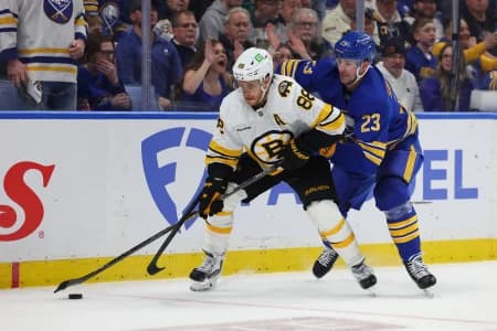 Boston Bruins right wing David Pastrnak (88) skates with the puck as Buffalo Sabres defenseman Mattias Samuelsson (23) defends during the third period in game one of the first round of the 2026 Stanley Cup Playoffs at KeyBank Center.