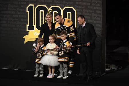 Boston Bruins center Patrice Bergeron (37) is given a golden stick by general manager Don Sweeney as a gift for his 1000 career point prior to a game against the Columbus Blue Jackets at TD Garden.