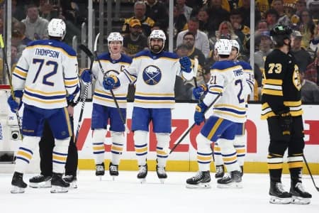 As Boston Bruins defenseman Charlie McAvoy (73) skates away, Buffalo Sabres right wing Alex Tuch (89) smiles at teammates after scoring during the first period of game six of the first round of the 2026 Stanley Cup Playoffs at TD Garden.