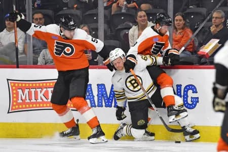 Boston Bruins center Oskar Steen (62) battles for the puck with Philadelphia Flyers defenseman Rasmus Ristolainen (55) and defenseman Cam York (8) during the first period at Wells Fargo Center.