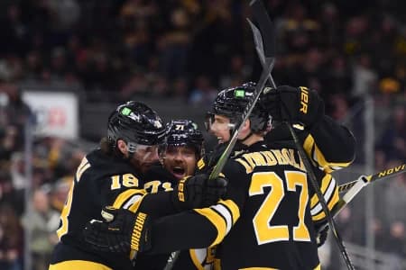 Boston Bruins center Pavel Zacha (18) left wing Viktor Arvidsson (71) defenseman Hampus Lindholm (27) celebrate a goal by defenseman Mason Lohrei (6) during the third period against the Los Angeles Kings at TD Garden.
