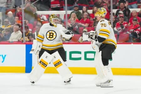 Boston Bruins goaltender Jeremy Swayman (1) passes goaltender Joonas Korpisalo (70) after being pulled against the Carolina Hurricanes during the second period at Lenovo Center.