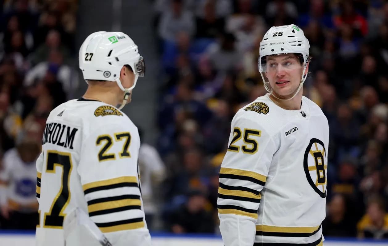 Boston Bruins defenseman Hampus Lindholm (27) and defenseman Brandon Carlo (25) talk during a stoppage in play against the Buffalo Sabres during the second period at KeyBank Center.