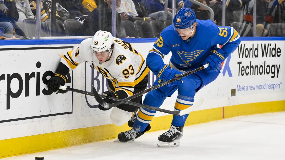 Boston Bruins center Fraser Minten (93) and St. Louis Blues defenseman Colton Parayko (55) battle for the puck during the third period at Enterprise Center