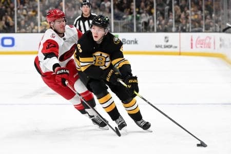 Boston Bruins defenseman Mason Lohrei (6) skates against Carolina Hurricanes right wing Andrei Svechnikov (37) during the third period at the TD Garden.