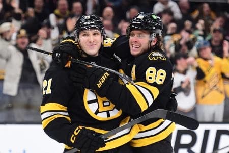 Boston Bruins right wing David Pastrnak (88) celebrates a goal by center Alex Steeves (21) against the Montreal Canadians during the first period at TD Garden.