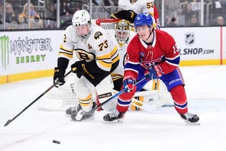 Boston Bruins defenseman Charlie McAvoy (73) and Montreal Canadiens right wing Cole Caufield (13) battle for the puck during the second period at TD Garden.