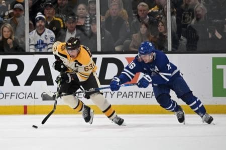 Boston Bruins left wing Brad Marchand (63) controls the puck against Toronto Maple Leafs right wing Mitchell Marner (16) during an overtime period at the TD Garden.