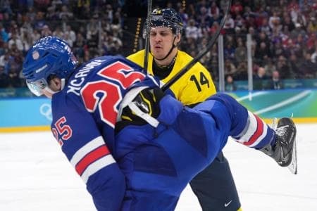 Charlie McAvoy of United States in action with Joel Eriksson Ek of Sweden in a men's ice hockey quarterfinal during the Milano Cortina 2026 Olympic Winter Games at Milano Santagiulia Ice Hockey Arena.