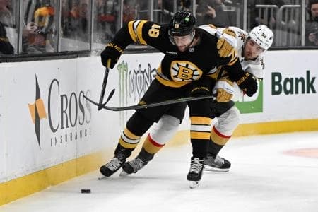 Vegas Golden Knights defenseman Dylan Coghlan (52) and Boston Bruins center Pavel Zacha (18) battle for the puck during the first period at the TD Garden