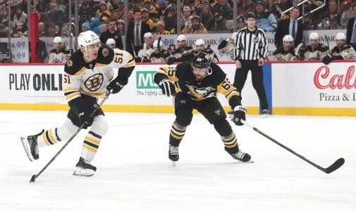 Boston Bruins center Matthew Poitras (51) shoots the puck against Pittsburgh Penguins defenseman Erik Karlsson (65) during the second period at PPG Paints Arena.