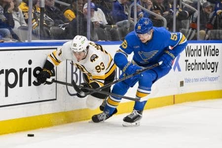 Boston Bruins center Fraser Minten (93) and St. Louis Blues defenseman Colton Parayko (55) battle for the puck during the third period at Enterprise Center.
