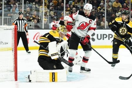 Boston Bruins goaltender Jeremy Swayman (1) makes a save on front of New Jersey Devils center Nico Hischier (13) during the second period at TD Garden.