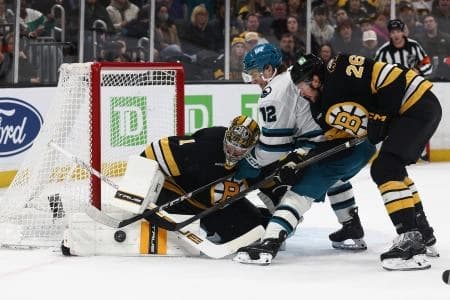 Boston Bruins goaltender Jeremy Swayman (1) makes a save as defenseman Andrew Peeke (26) tries to keep San Jose Sharks left wing William Eklund (72) from the rebound during the third period at TD Garden.