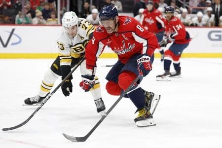 Washington Capitals left wing Alex Ovechkin (8) skates with the puck as Boston Bruins defenseman Charlie McAvoy (73) defends during the first period at Capital One Arena.