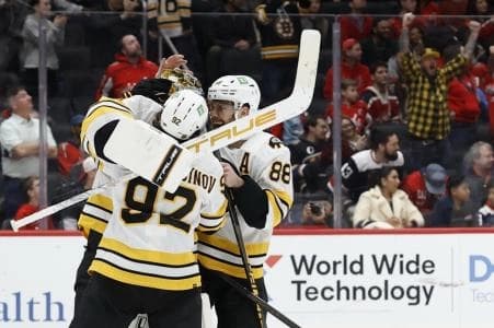 Boston Bruins goaltender Jeremy Swayman (1) celebrates with Bruins center Marat Khusnutdinov (92) and Bruins right wing David Pastrnak (88) after their shootout win against the Washington Capitals at Capital One Arena.