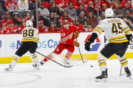Detroit Red Wings defenseman Moritz Seider (53) handles the puck against Boston Bruins right wing David Pastrnak (88) during the second period at Little Caesars Arena.