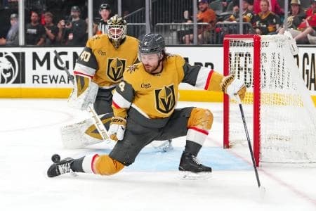 Vegas Golden Knights defenseman Rasmus Andersson (4) looks to deflect a Utah Mammoth shot as goaltender Akira Schmid (40) returns to his net during the third period at T-Mobile Arena.