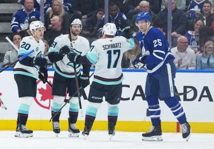 Seattle Kraken center Shane Wright (51) celebrates after scoring a goal against the Toronto Maple Leafs with right wing Eeli Tolvanen (20) left wing Jaden Schwartz (17) during the first period at Scotiabank Arena.