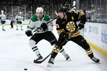 Boston Bruins defenseman Charlie McAvoy (73) passes the puck in front of Dallas Stars left wing Jason Robertson (21) during the second period at the TD Garden.