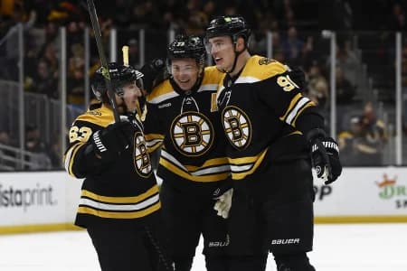 Boston Bruins defenseman Nikita Zadorov (91) (right) is congratulated by left wing Brad Marchand (63) and defenseman Charlie McAvoy (73) after scoring against the Vegas Golden Knights during the first period at TD Garden