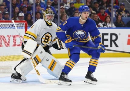 Boston Bruins goaltender Jeremy Swayman (1) and Buffalo Sabres center Josh Norris (9) look for the puck during the second period in game two of the first round of the 2026 Stanley Cup Playoffs at KeyBank Center.
