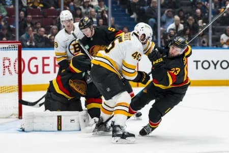 Boston Bruins defenseman Jonathan Aspirot (45) checks Vancouver Canucks forward Max Sasson (63) in the third period at Rogers Arena.